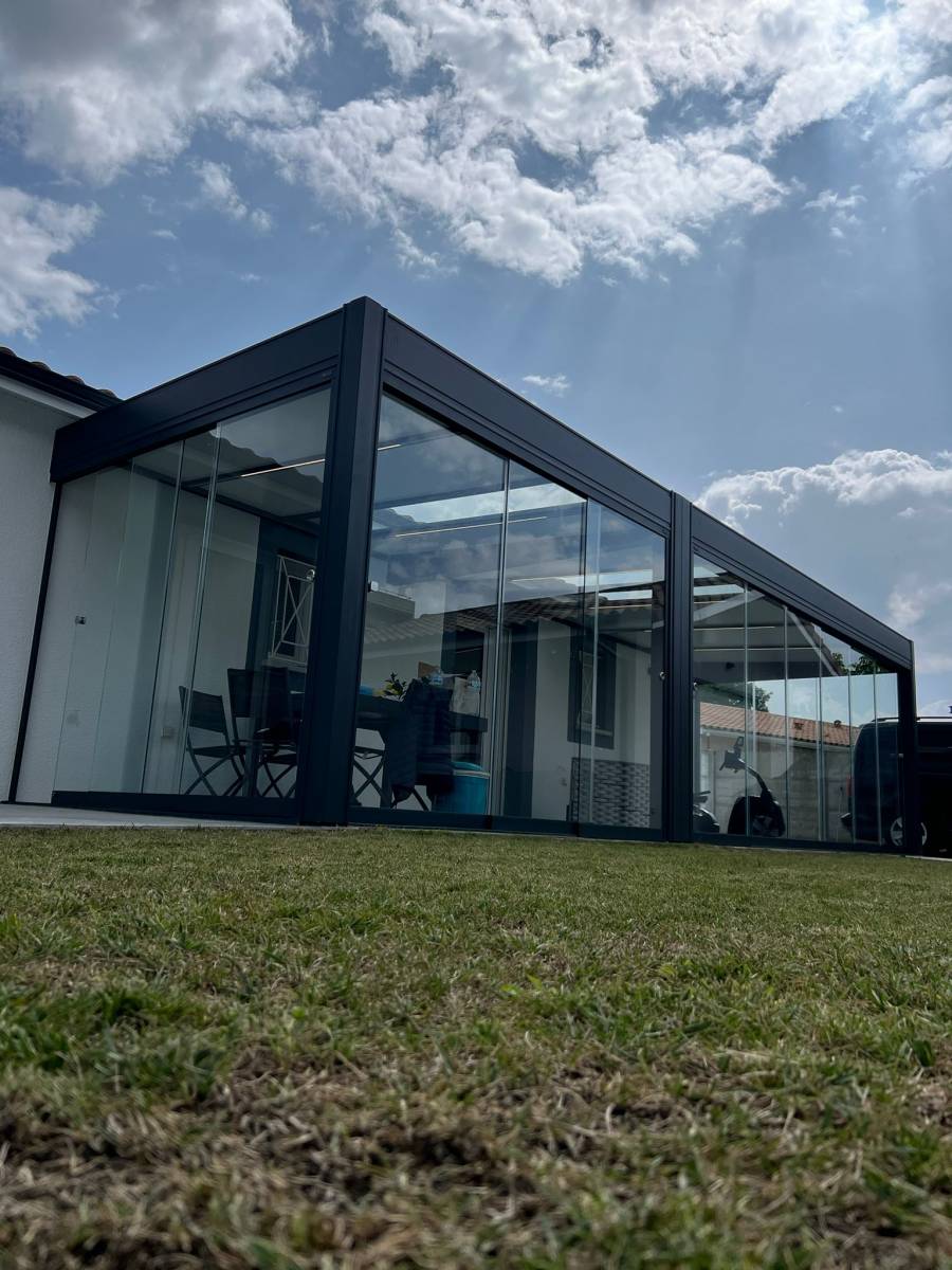 Pergola toit fixe en aluminium de la marque Rénoval et ses rideaux de verres à Audenge sur le bassin d'Arcachon.